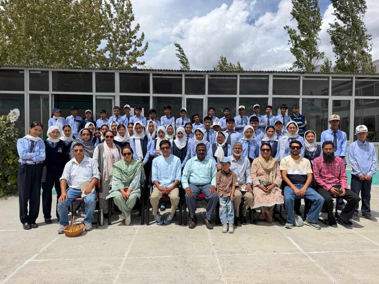 Group photograph of senior students and teaching staff in the school courtyard